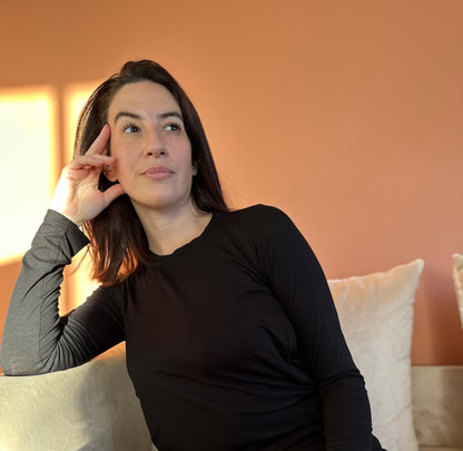 Photo de la marque Nuance lactée, femme  assise, portant le maillot de corps "peau à Peau" de couleur noire. Maillot de corps d'allaitement